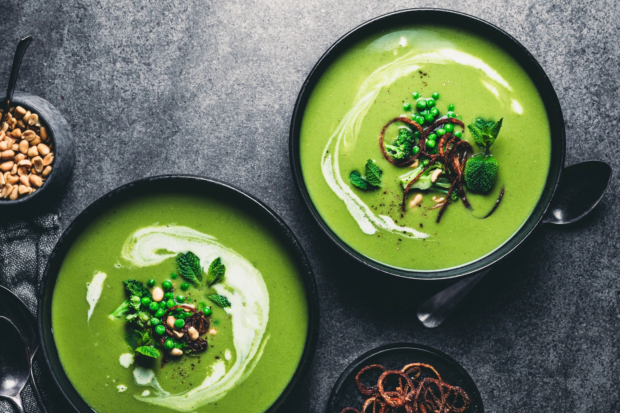 Green pea cream soup styled in a dark plate